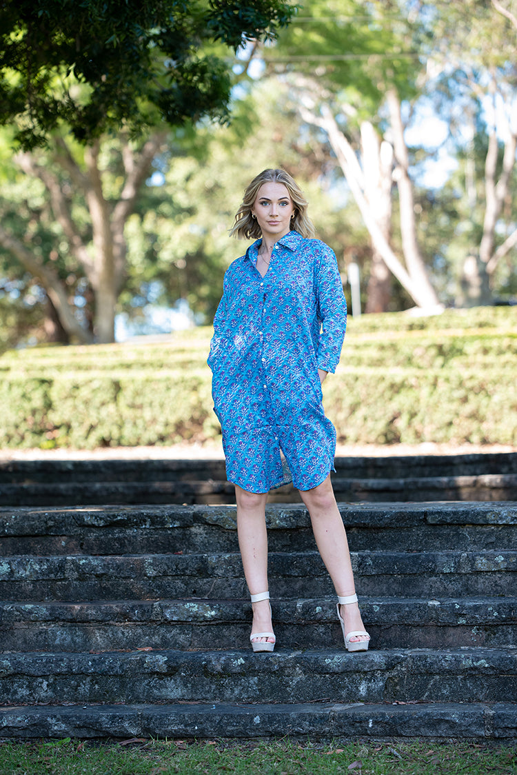 Our Nisa Shirt Dress is a soft, 100% cotton, button through dress featuring collar and 3/4 sleeves. Mehndi block print pattern in a blue and purple colourway.