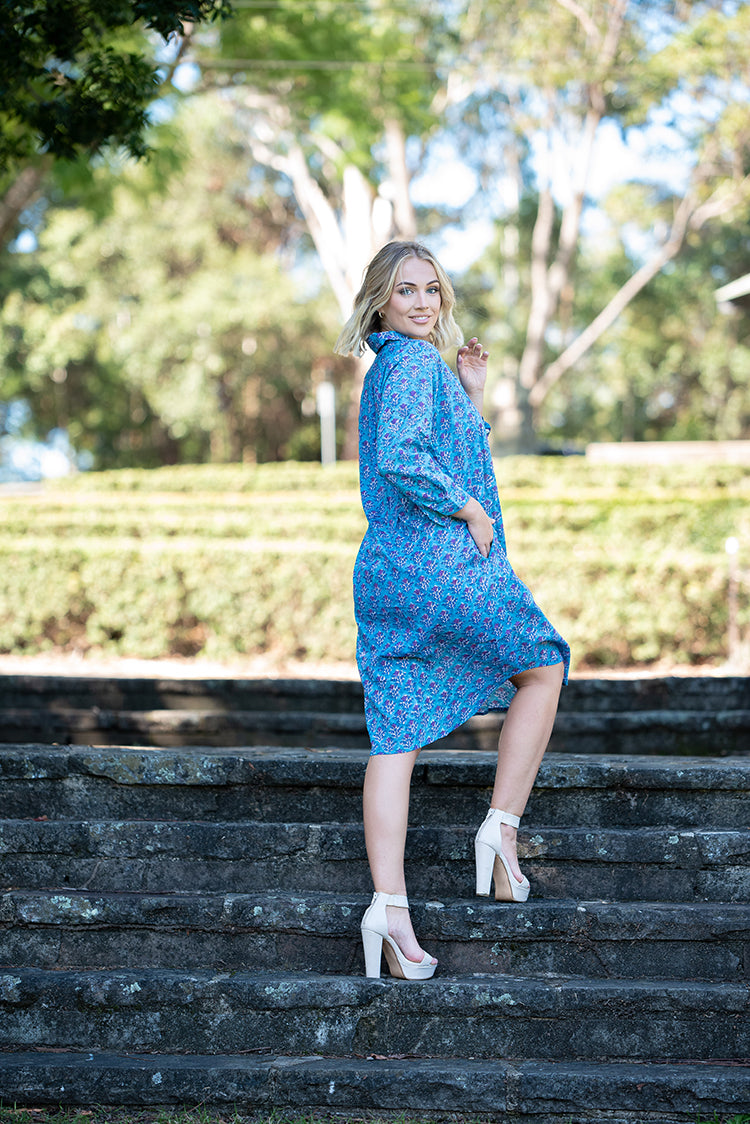 Our Nisa Shirt Dress is a soft, 100% cotton, button through dress featuring collar and 3/4 sleeves. Mehndi block print pattern in a blue and purple colourway.