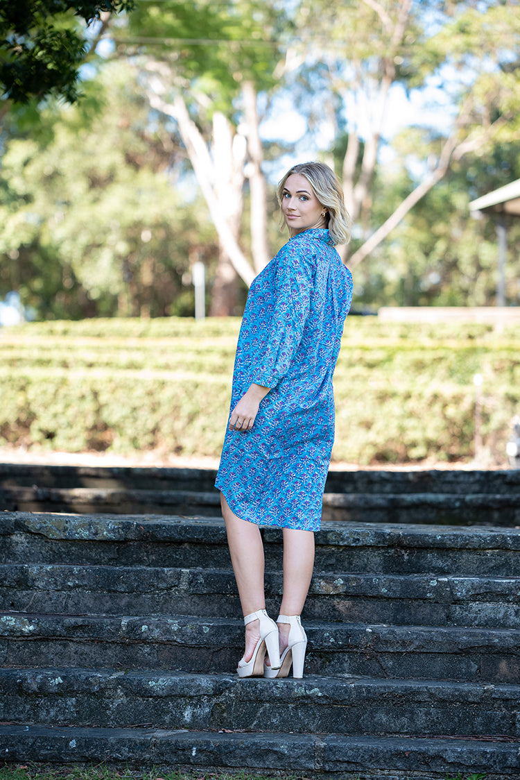 Our Nisa Shirt Dress is a soft, 100% cotton, button through dress featuring collar and 3/4 sleeves. Mehndi block print pattern in a blue and purple colourway.