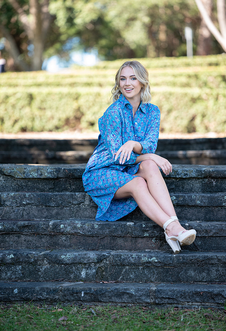 Our Nisa Shirt Dress is a soft, 100% cotton, button through dress featuring collar and 3/4 sleeves. Mehndi block print pattern in a blue and purple colourway.